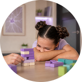 Niña interactuando con bloques sensoriales en una imagen relacionada con autismo, autorregulación y procesamiento sensorial.